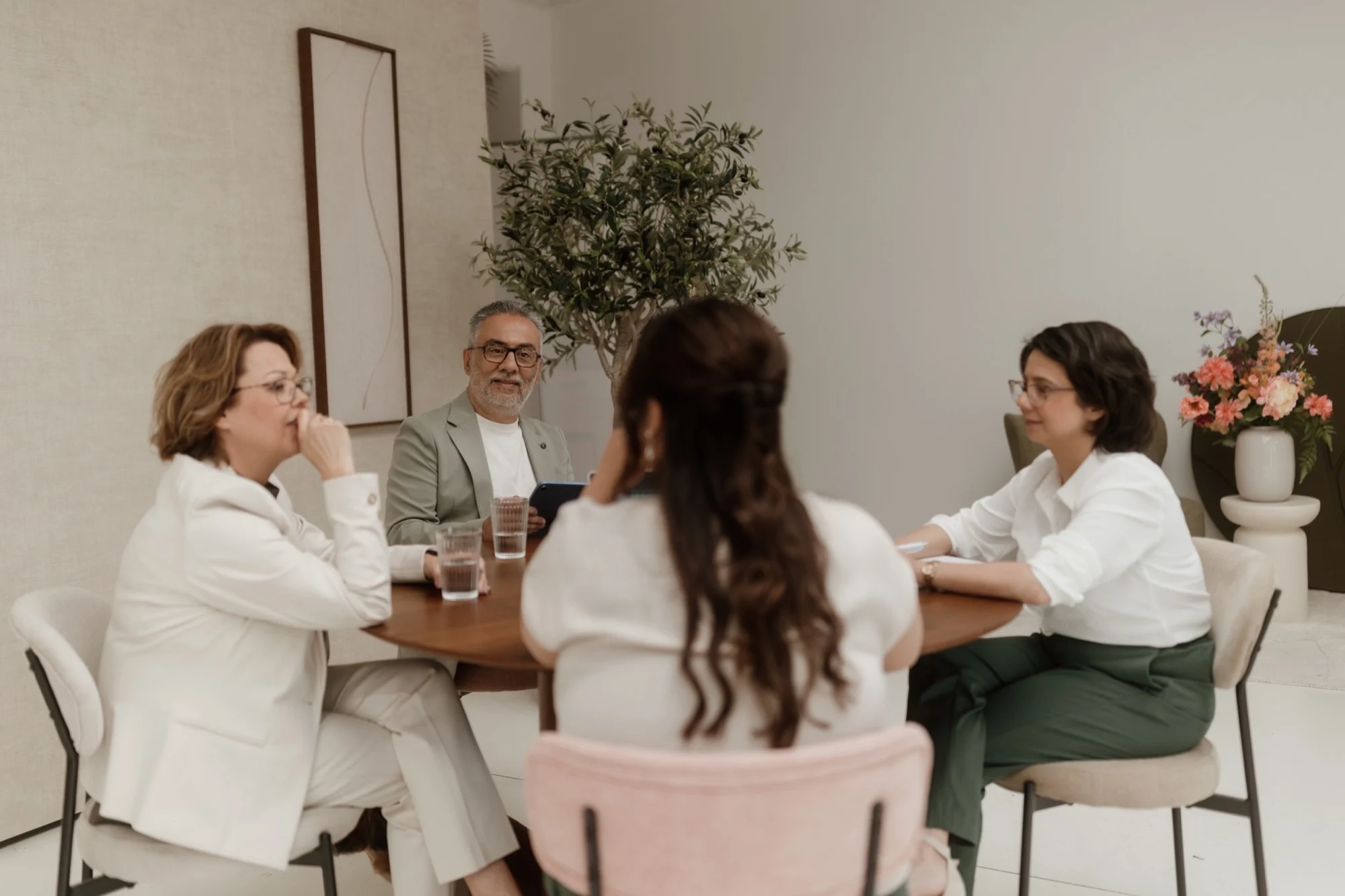 Vier collega's voeren een gesprek aan een ronde tafel